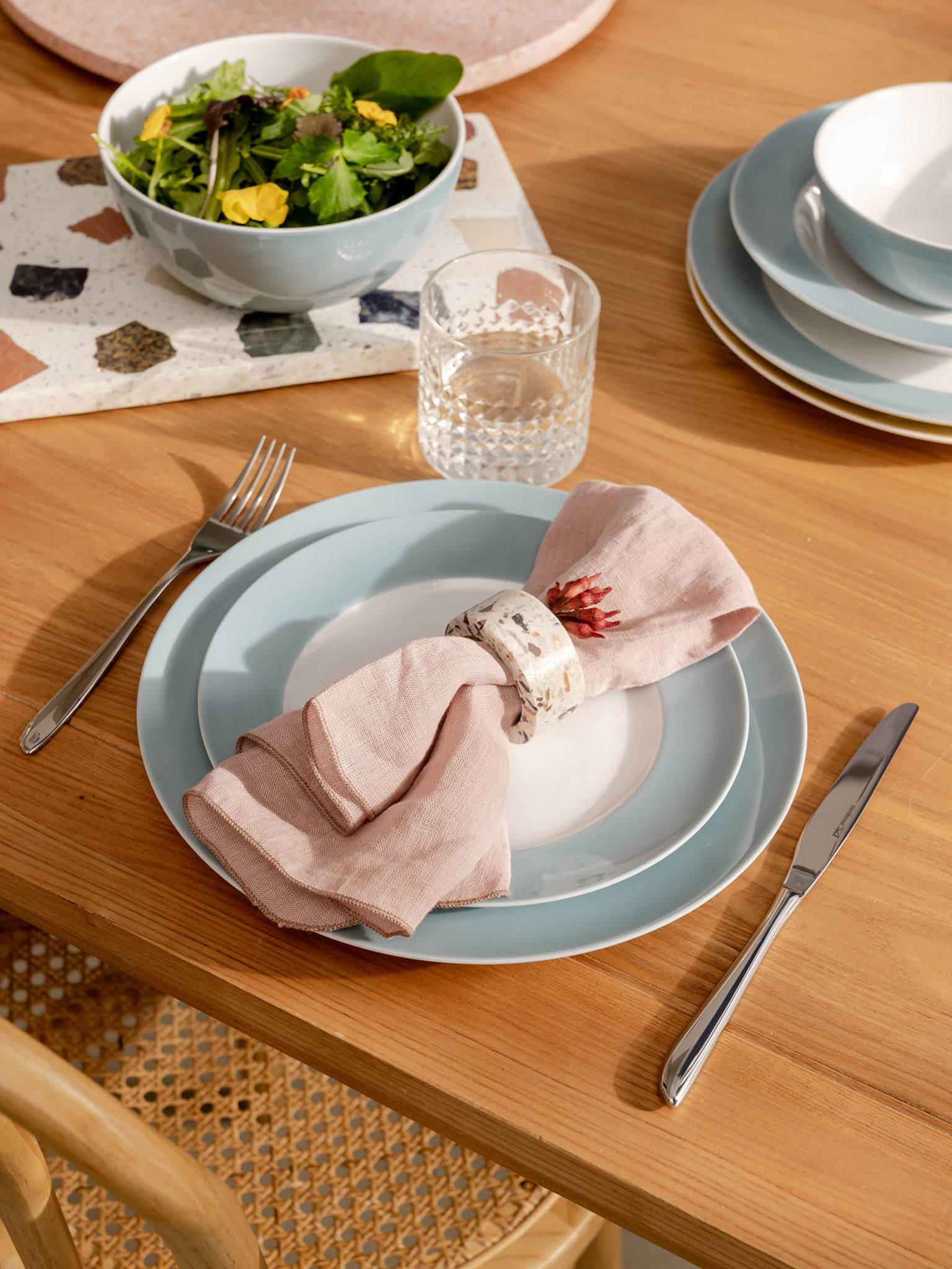 Thomas Sunny Day Soft Blue Teller mit rosa Leinen Serviette auf einem Holztisch